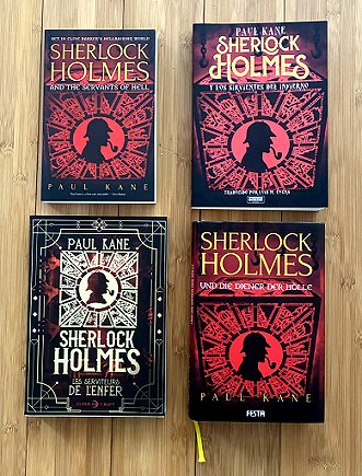 photograph showing English, French, German and Spanish editions of Sherlock Holmes and the Servants of Hell by Paul Kane, lying on a wooden surface